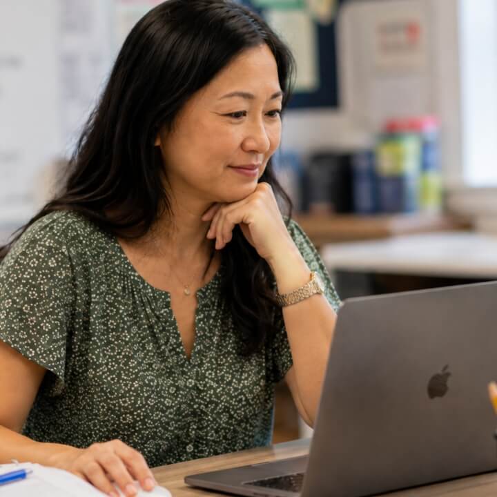 Asian woman at desk with laptop