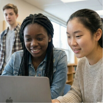 two girls with laptop and boy in background2